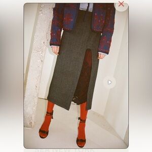 The Lucas suiting wool skirt features a high side slit with lace trim.